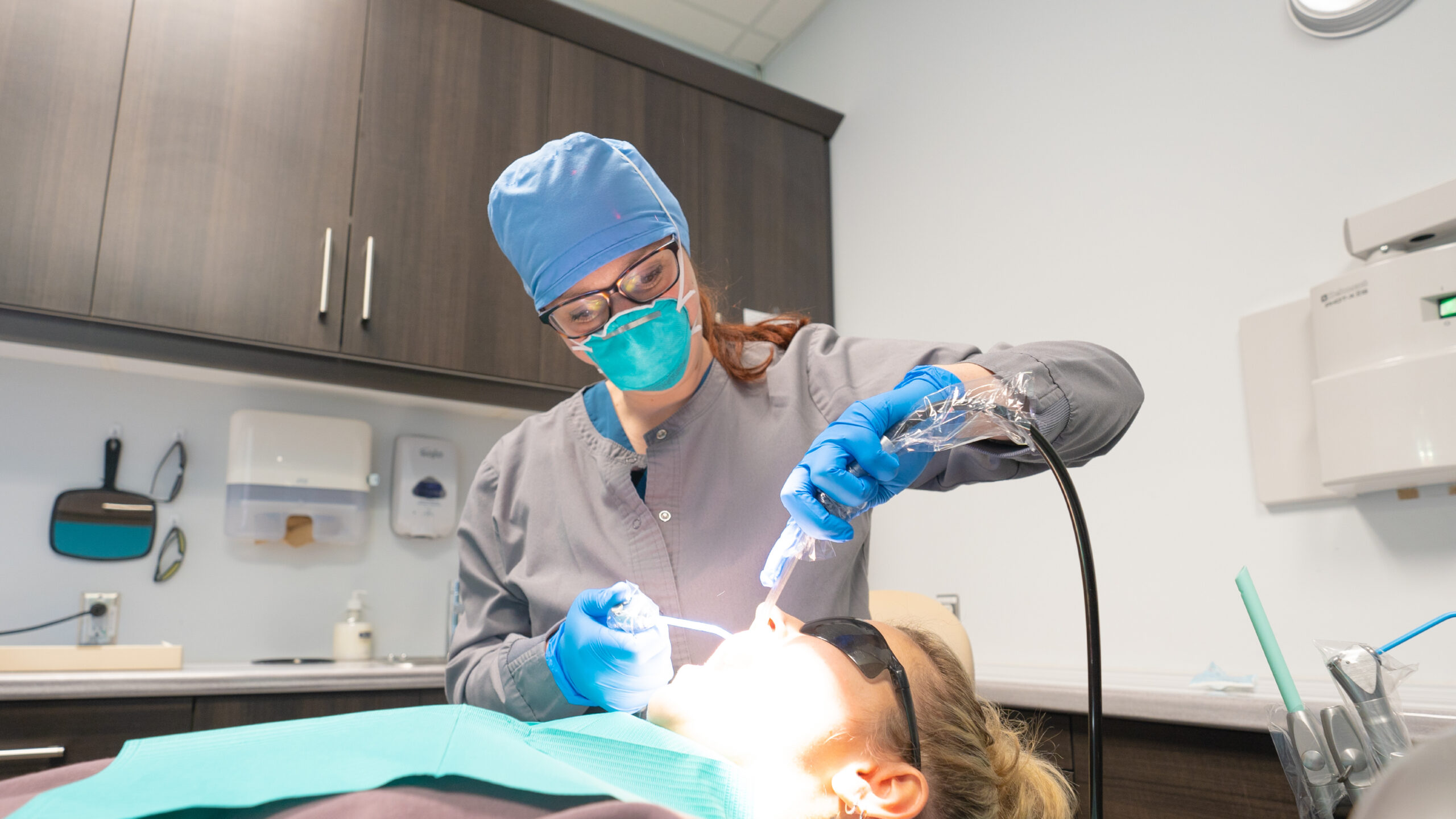 Dental hygienist doing a cleaning on a patient.